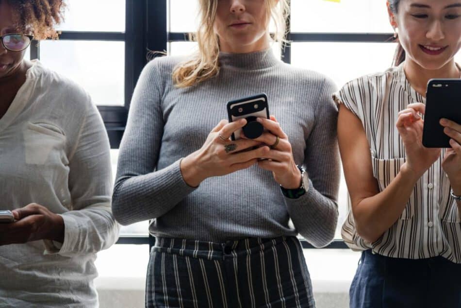 Three women using their phones