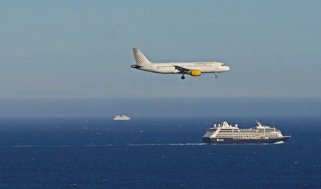 Veuling plane landing with a cruise ship in the background