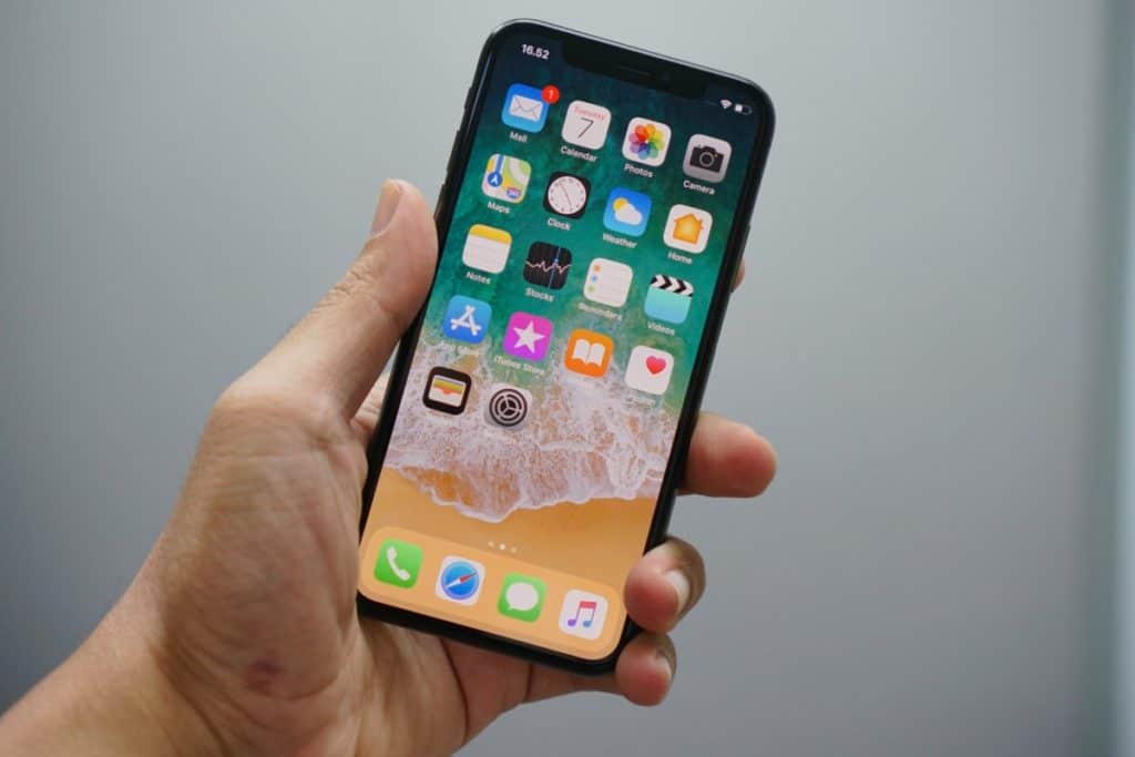 Man holding a phone showing his home screen