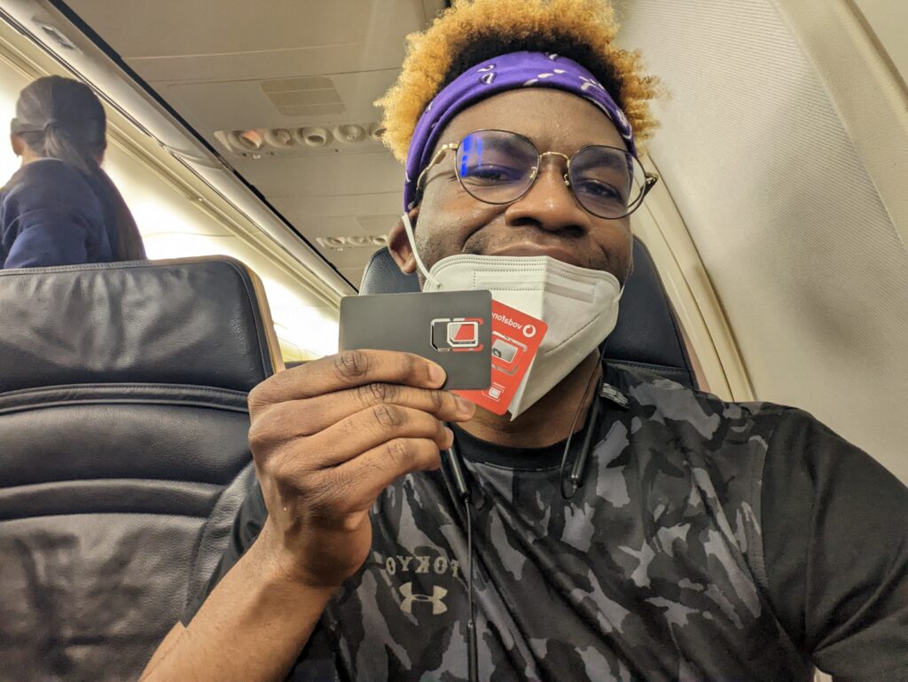 Adu from Phone Travel Wiz holding Orange Spain and Vodafone Spain SIM cards on a plane at Josep Tarradellas Barcelona–El Prat Airport