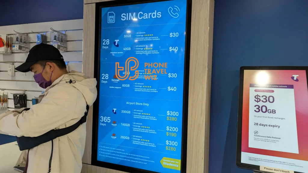An Electronic Screen with Telstra and Boost Mobile Australia SIM Card Starter Packs at the Welcome Center at Melbourne-Tullamarine Airport